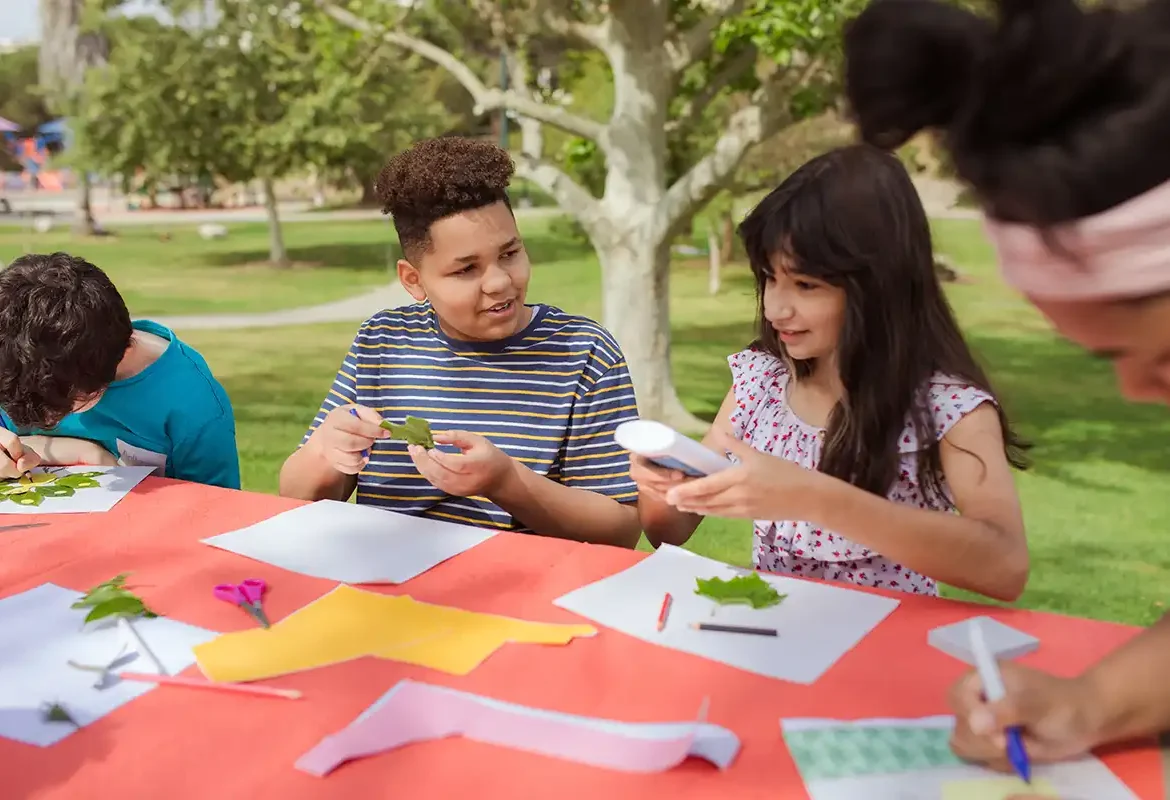 School Kids in the Park at a Table doing art.